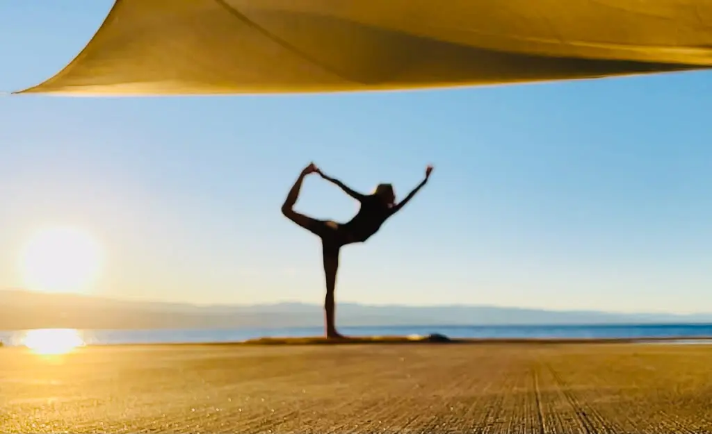 Daniela Schimpl beim Yoga am Strand im Sonnenuntergang